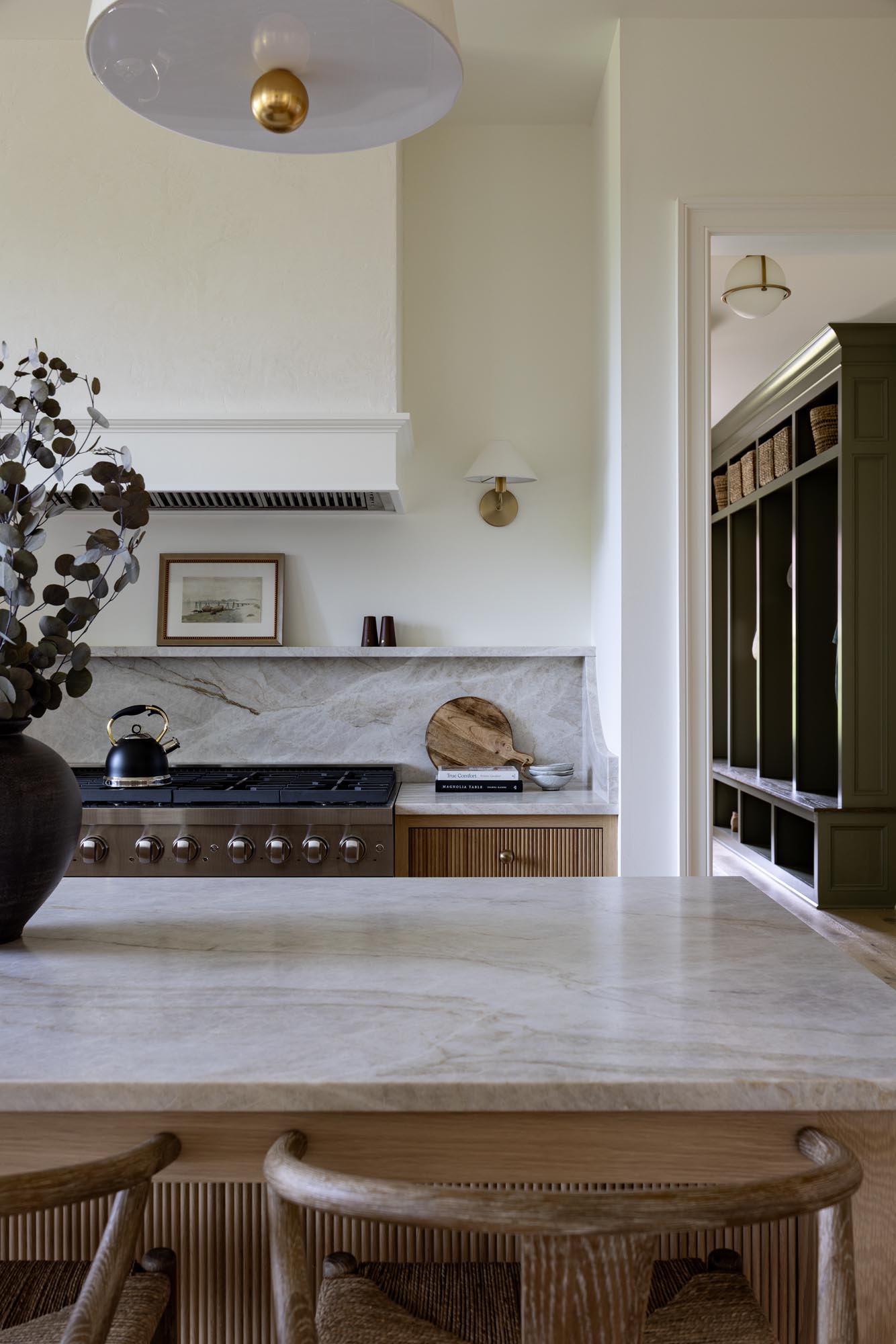 Taj Mahal quartzite island countertop with veining in front of the range and doorway to the mudroom