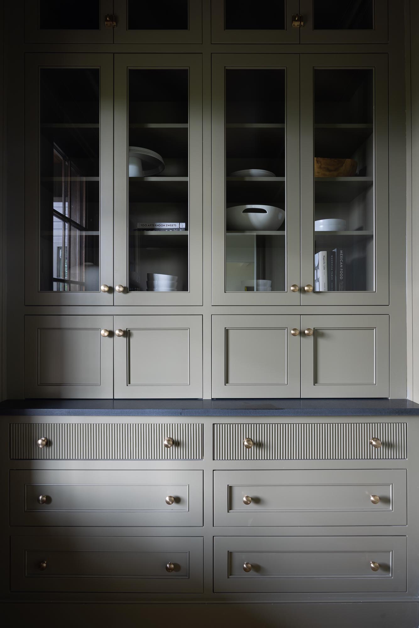 Glass-front Crownsville Gray scullery cabinets with reeded drawers and brass knobs