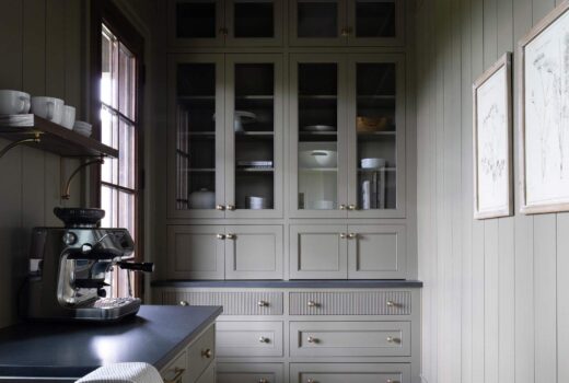 Finished scullery with Crownsville Gray cabinetry, dark counters, a wood shelf, and framed botanical prints.